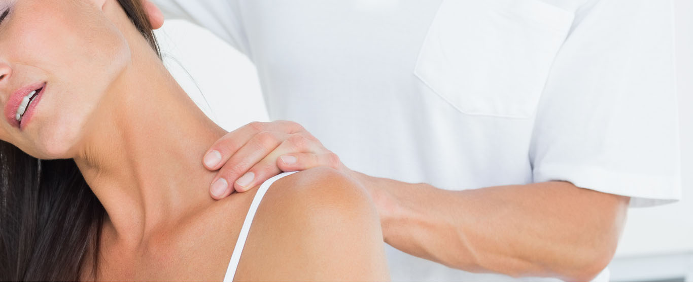 Clinician examining a patient’s neck and shoulder