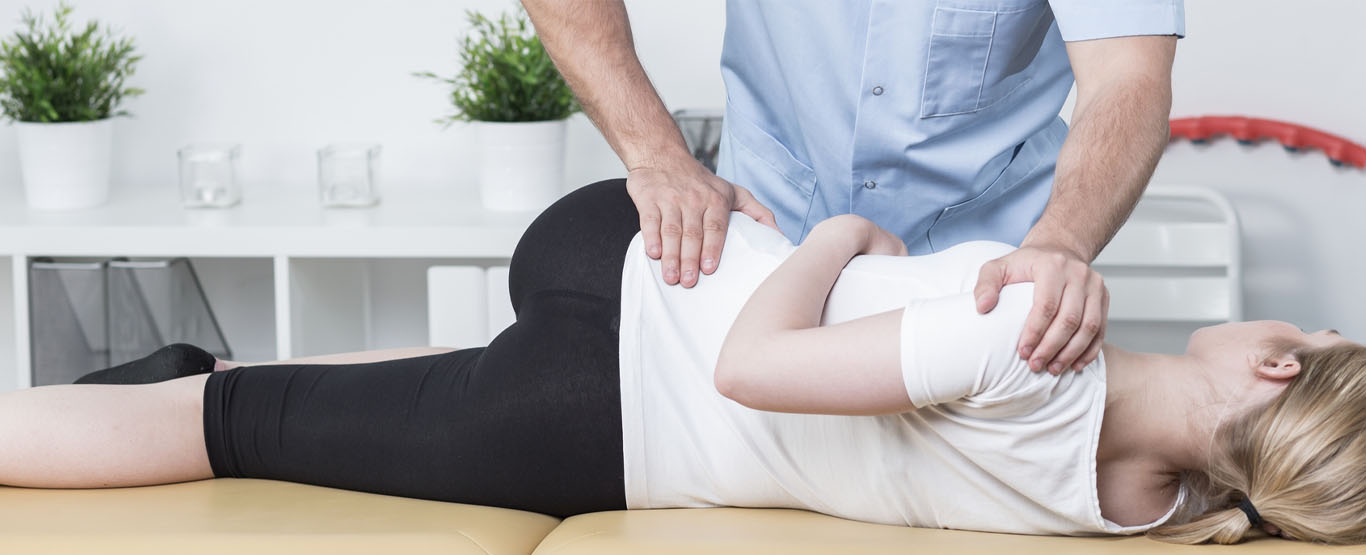 Clinician supporting a patient during a side-lying adjustment