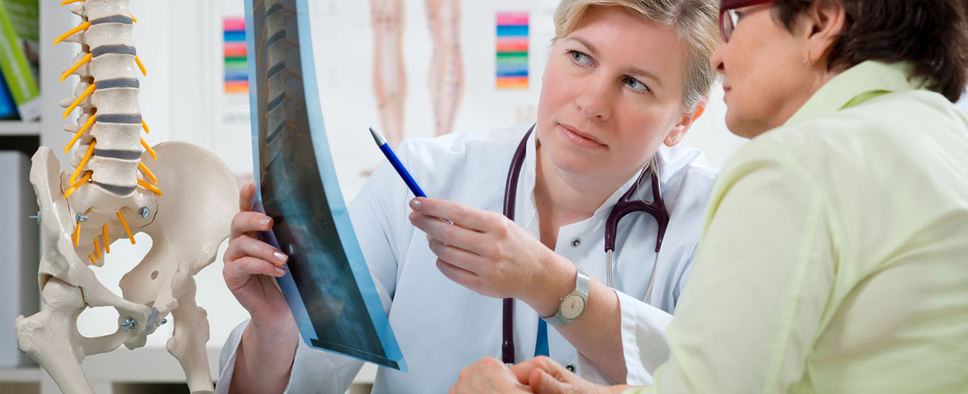 Clinician explaining a spine X-ray to a patient