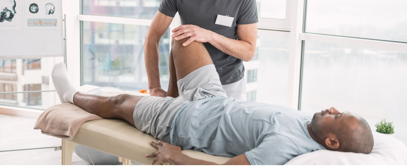 Therapist guiding a patient’s bent-leg exercise