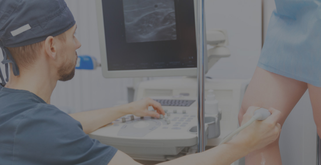 Clinician performing an ultrasound examination of a leg